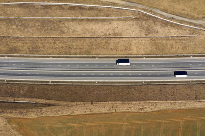 Aerial top view of cars and trucks passing on a highway, drone shot
