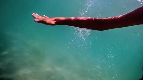 Cropped hand of woman swimming in sea