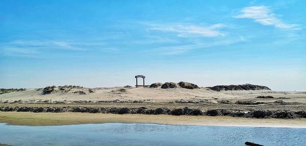 Scenic view of beach against blue sky