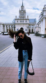 Portrait of young woman standing on street