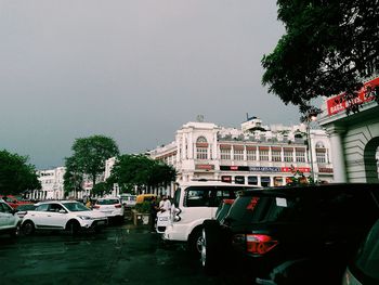 Cars on road in city against clear sky