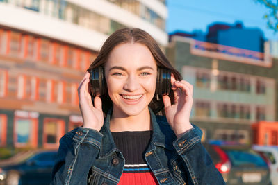 Young energetic cheerful caucasian woman wearing headphones. dressed in a denim