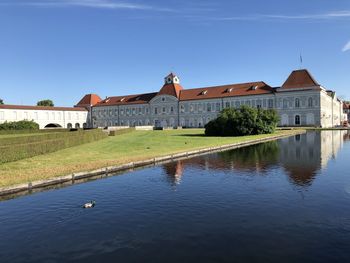 Houses by river against sky