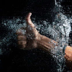 Man swimming in water against black background