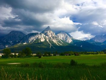 Scenic view of field and mountains against sky