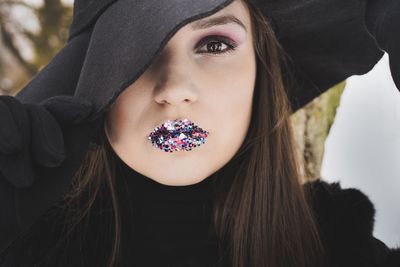 Close-up portrait of young woman wearing glitter lipstick