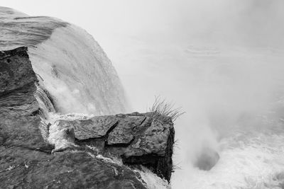 Close-up of rocks by sea against sky