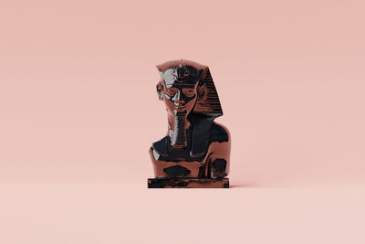 Close-up of figurine against pink background