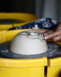 Wheel throwing ceramic bowl - trimming with hand and tool