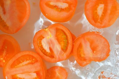 Close-up fresh slices of tomato on white background. slices of tomato in sparkling water on white