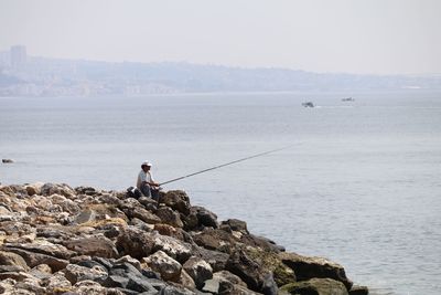 Man fishing by beach