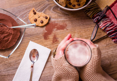 High angle view of hand holding cookies on table