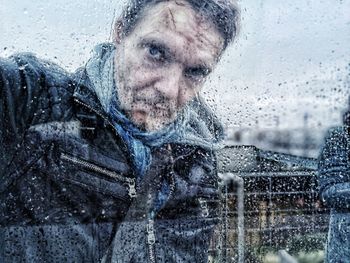 Portrait of smiling man in snow during rainy season