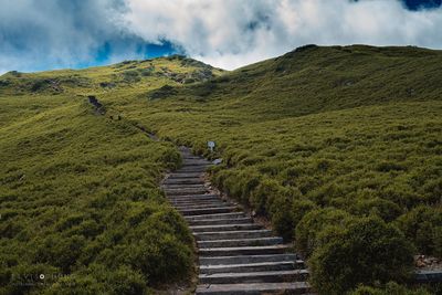 Scenic view of steps leading towards mountains against sky