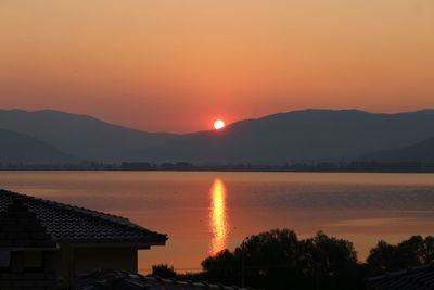 Scenic view of lake against romantic sky at sunset