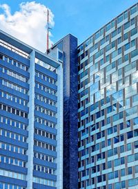 Low angle view of modern buildings against blue sky