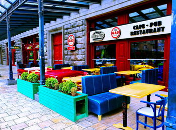 Chairs and tables at sidewalk cafe in city