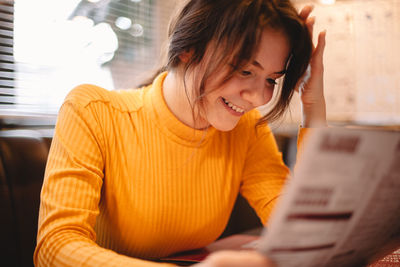 Young woman using mobile phone at home