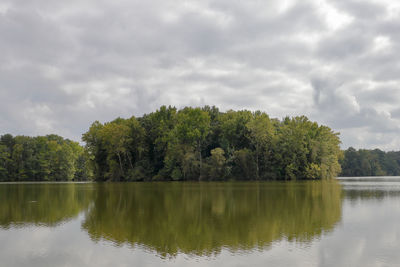 Scenic view of lake by trees against sky