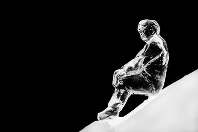 Close-up of frozen statue against black background