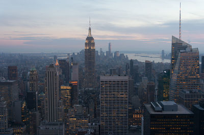 Illuminated cityscape against sky during sunset