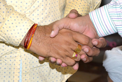 Midsection of men shaking hands