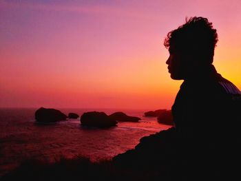 Silhouette man at beach against sky during sunset