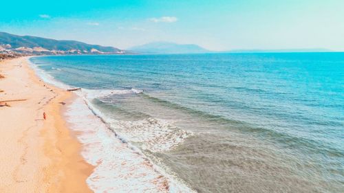 Scenic drone view of beach against sky