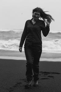 Tourist on black beach at strong wind monochrome scenic photography