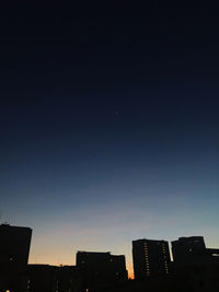 Low angle view of silhouette buildings against sky at dusk