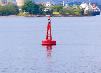 Close-up of red lighthouse in sea against sky