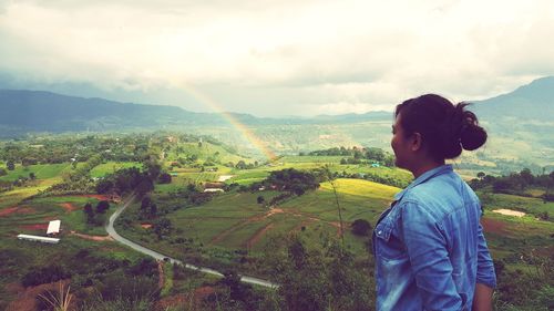 Woman looking at view while standing against sky