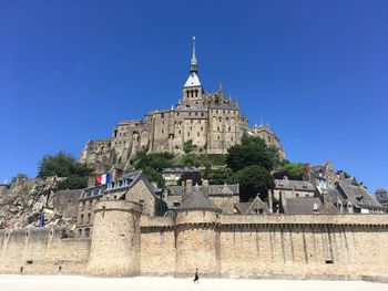 Low angle view of historic building against clear blue sky