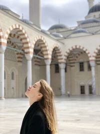 Woman standing against building