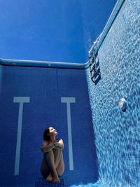 Woman sitting in swimming pool