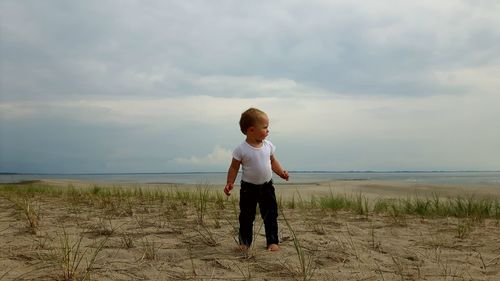 Full length of boy on beach against sky