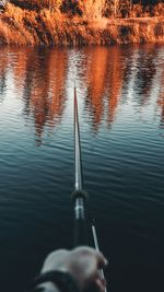 Cropped hand of person fishing in lake