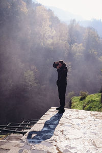 Rear view of man standing on tree