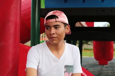 Young man sitting on slide in playground