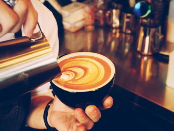 Close-up of hand holding coffee cup