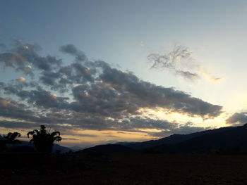 Scenic view of silhouette mountains against sky at sunset