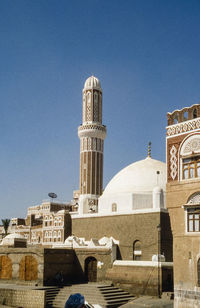 View of buildings against clear blue sky