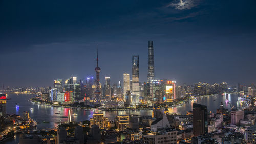Illuminated buildings in city against sky at night