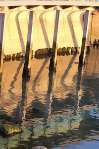 Reflection of bridge in puddle on river