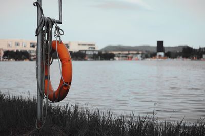 Close-up of rope hanging over river against sky