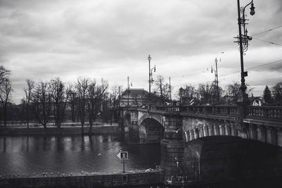 Bridge over river against cloudy sky