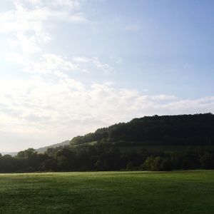 Scenic view of grassy field against cloudy sky