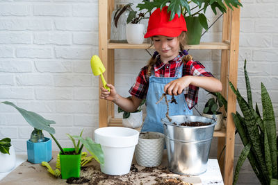 Portrait of smiling young woman standing in kitchen