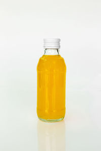 Close-up of yellow glass bottle against white background