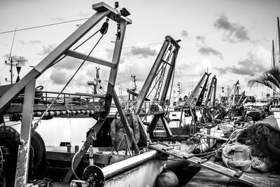 Cranes at harbor against sky